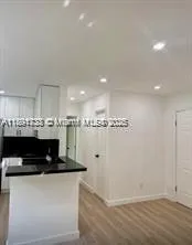 a view of kitchen with stainless steel appliances kitchen island granite countertop a stove a microwave and a refrigerator