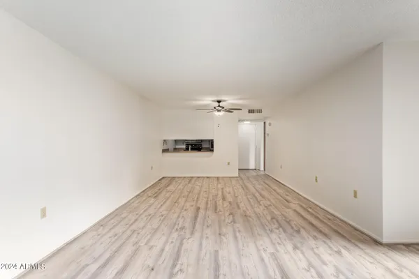 a view of empty room with wooden floor and windows