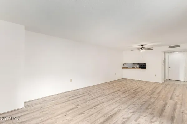 a view of empty room with wooden floor and window