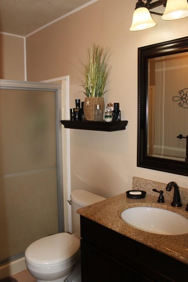 6110 Hubbard Road Acton, CA 93510 - Photo 32 of 46 a bathroom with a granite countertop toilet sink and mirror