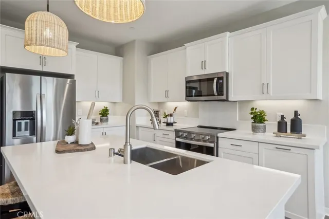 a kitchen with granite countertop a stove a sink and a microwave