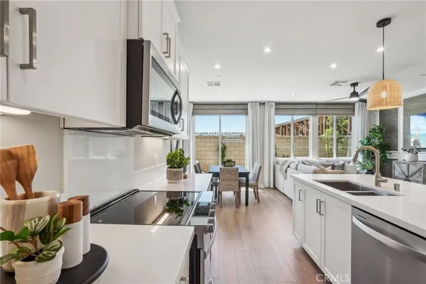 a kitchen with stainless steel appliances granite countertop a sink a stove and a wooden floors