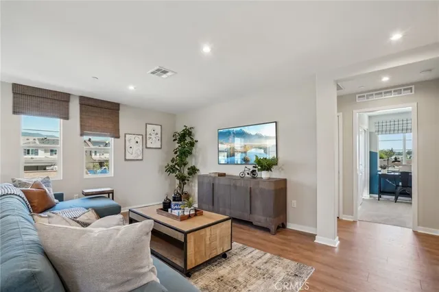 a living room with furniture and a wooden floor