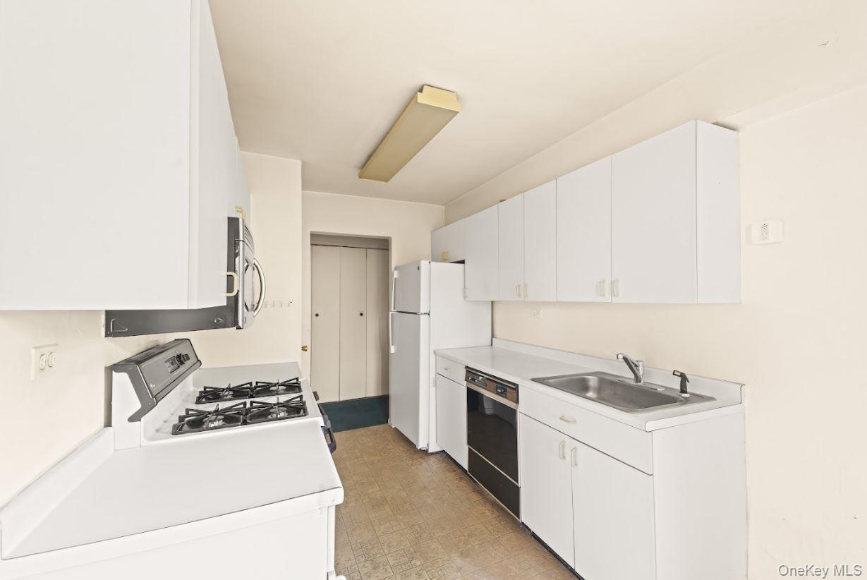 18-75 Corporal Kennedy Street, Unit 3J Queens, NY 11360 - Photo 5 of 27 a kitchen with a stove a sink and a refrigerator