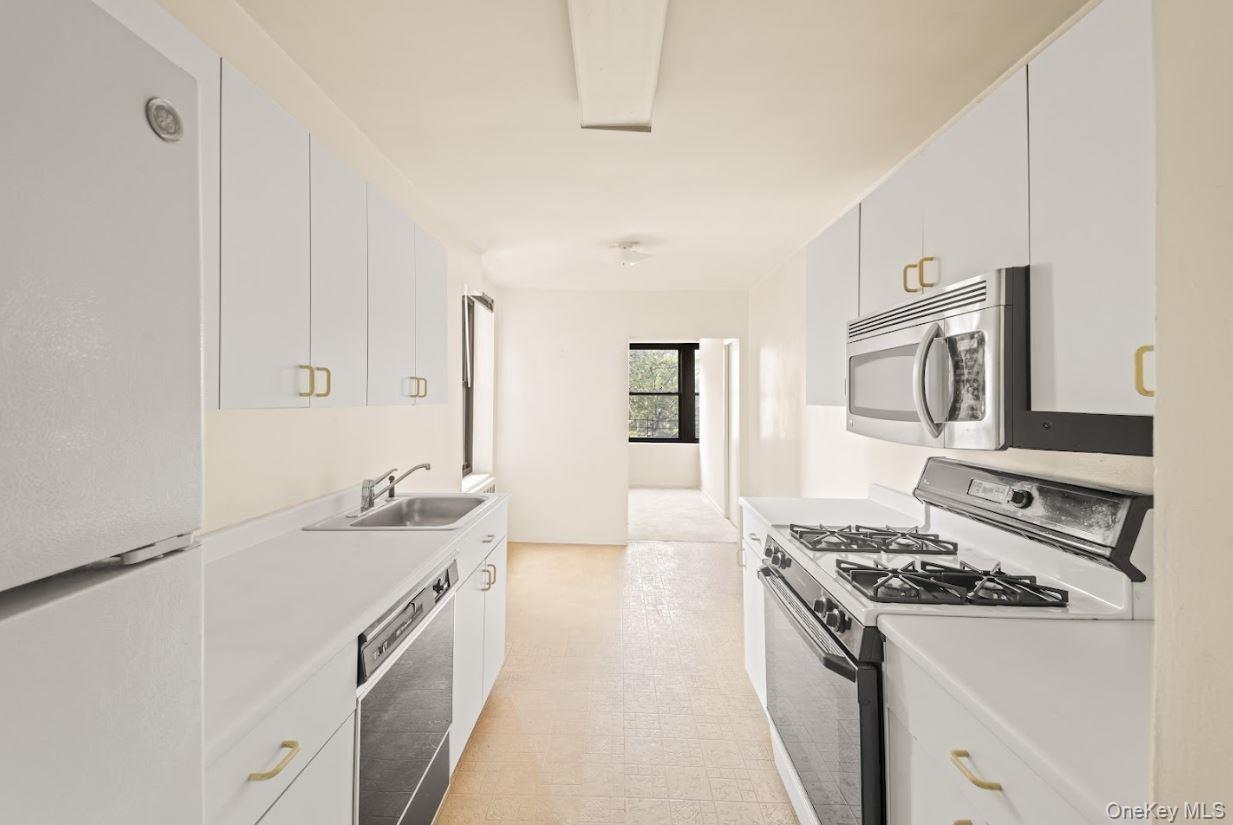 18-75 Corporal Kennedy Street, Unit 3J Queens, NY 11360 - Photo 6 of 27 a kitchen with stainless steel appliances granite countertop a sink stove and refrigerator