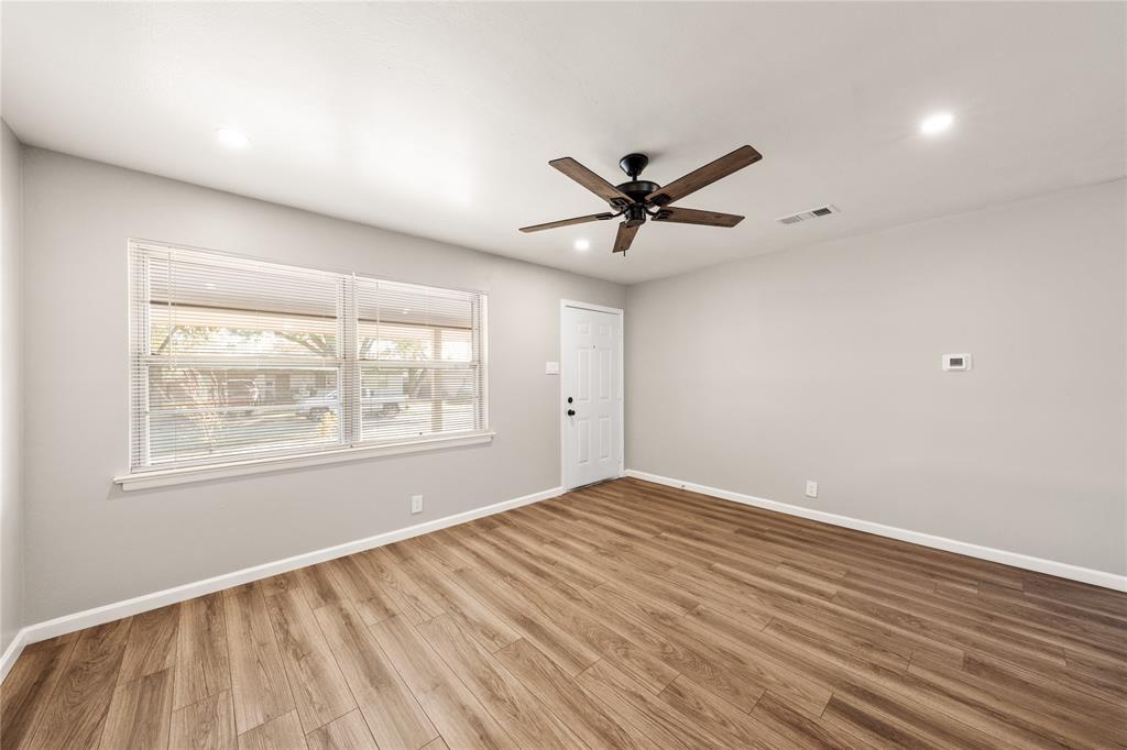415 Walnut Street Duncanville, TX 75116 - Photo 4 of 22 an empty room with wooden floor and windows