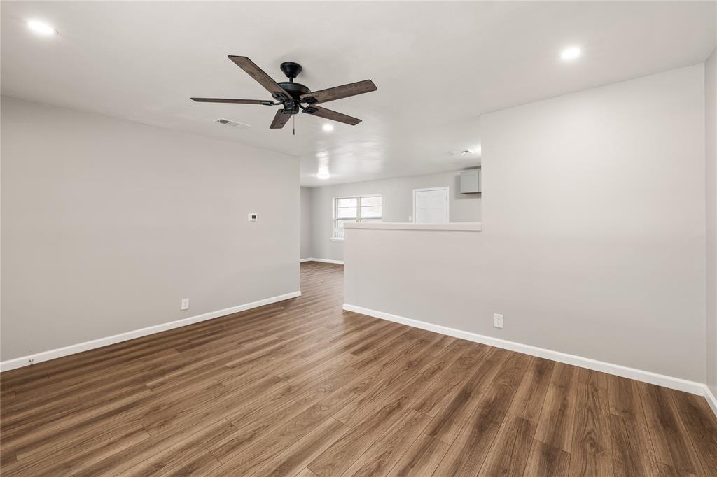 415 Walnut Street Duncanville, TX 75116 - Photo 5 of 22 an empty room with wooden floor fan and windows