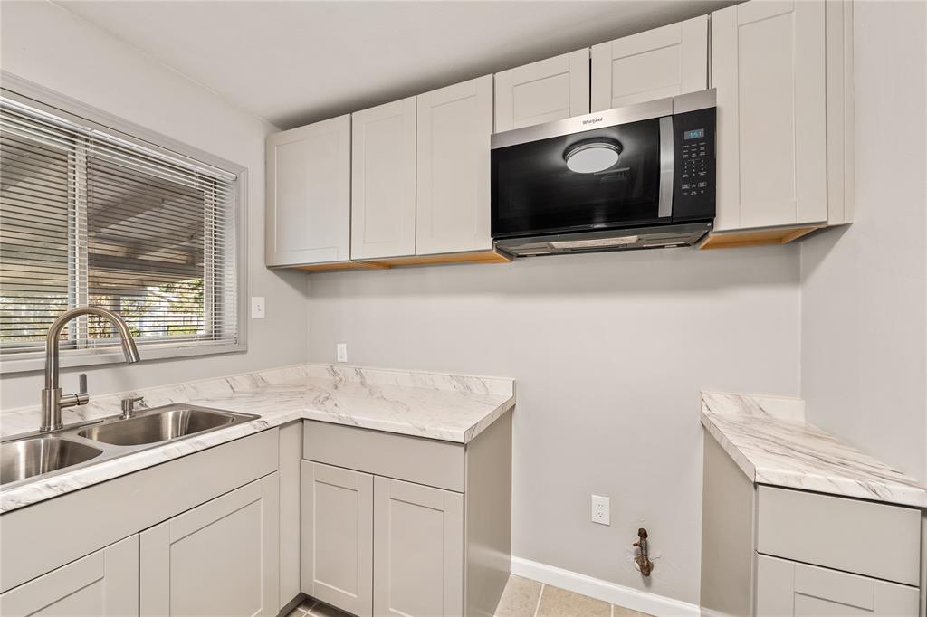 415 Walnut Street Duncanville, TX 75116 - Photo 10 of 22 a kitchen with stainless steel appliances granite countertop white cabinets a microwave oven and a sink