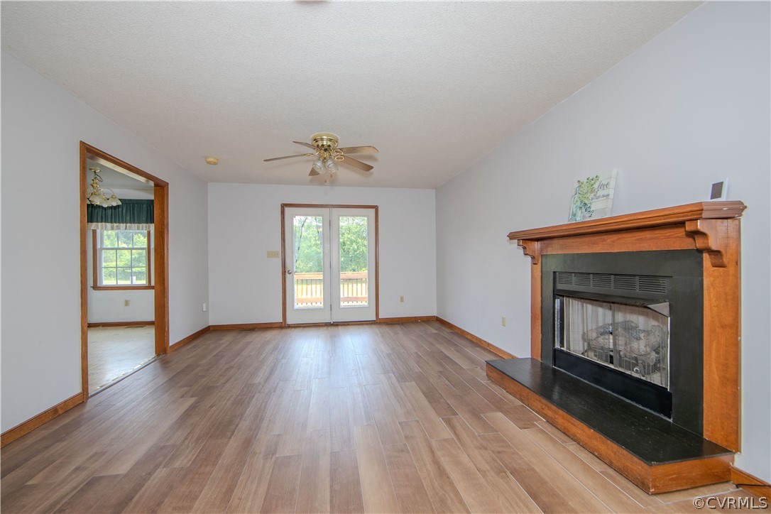 15895 Loving Union Road Disputanta, VA 23842 - Photo 9 of 42 a view of an empty room with wooden floor fireplace and a window