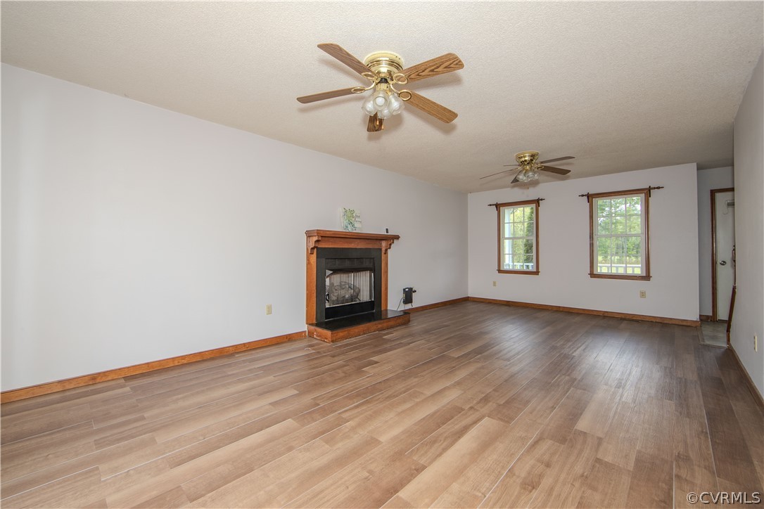 15895 Loving Union Road Disputanta, VA 23842 - Photo 10 of 42 an empty room with wooden floor chandelier fan and windows