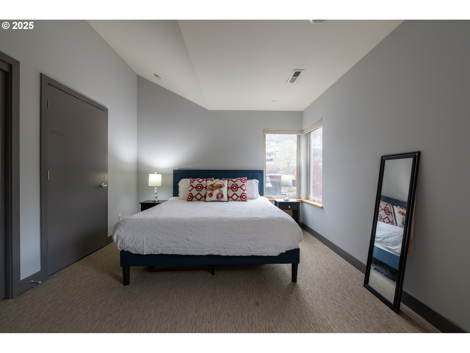 26 Mosier Creek Place, Unit 26 Mosier, OR 97040 - Photo 19 of 38 a bedroom with a bed a mirror on desk and a window