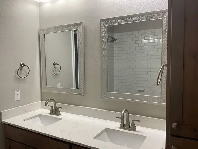 a bathroom with a sink vanity and shower