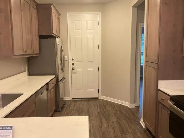 a kitchen with a refrigerator and a stove top oven