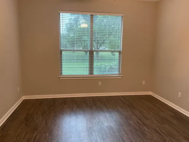 a view of a room with wooden floor and windows