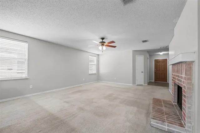 a view of a livingroom with a fireplace and chandelier fan