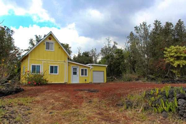 a front view of house with yard and trees around
