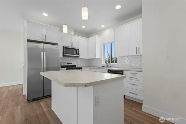 a kitchen with a sink a microwave a refrigerator and cabinets