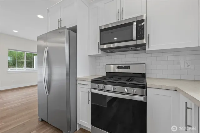 a kitchen with stainless steel appliances a stove microwave and refrigerator
