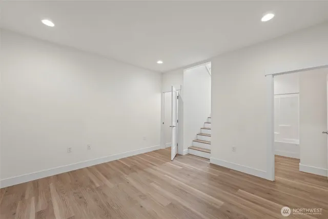 a view of a hallway with stairs and wooden floor
