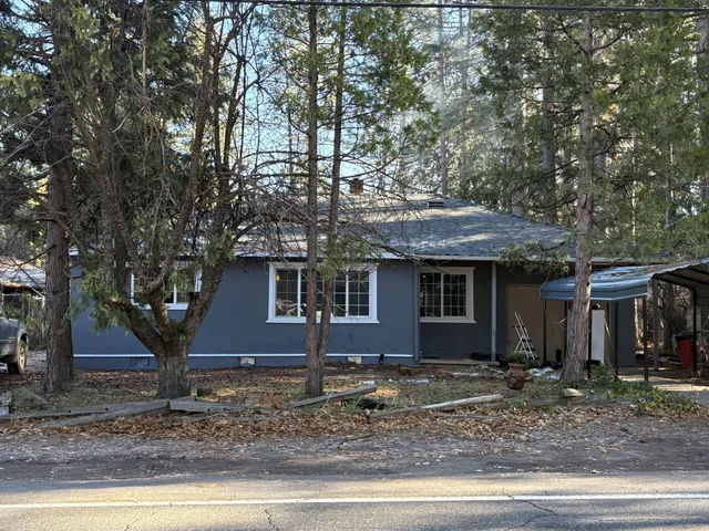 a view of a house with a yard and large tree