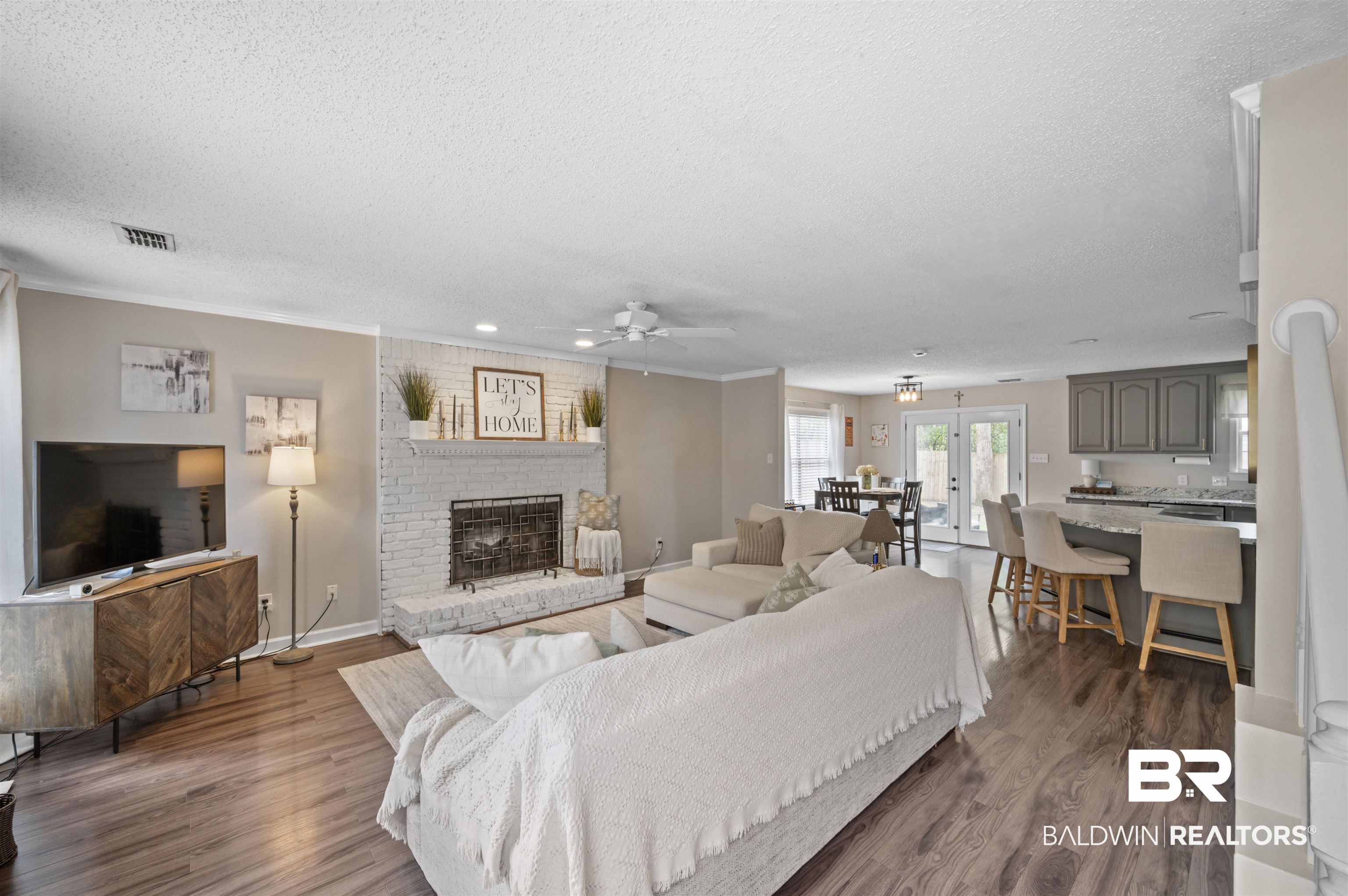 1066 Linlen Avenue Mobile, AL 36609 - Photo 4 of 22 Living room with crown molding, a textured ceiling, ceiling fan, a fireplace, and wood finished floors