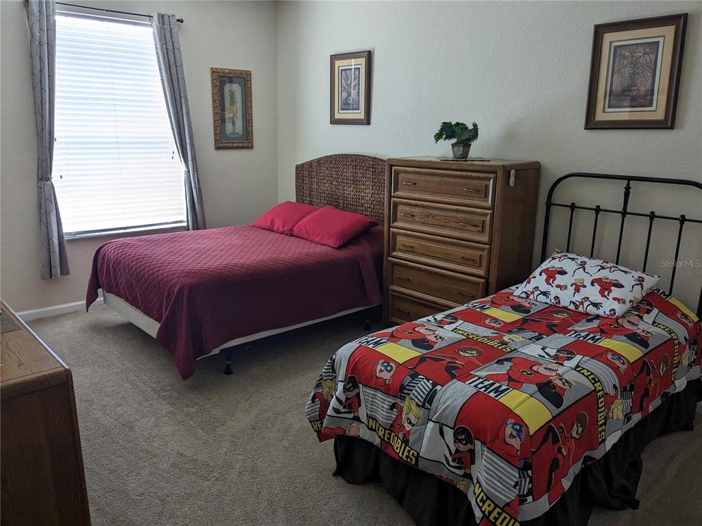 2817 Almaton Loop, Unit 304 Kissimmee, FL 34747 - Photo 12 of 26 a bedroom with two beds and a dresser
