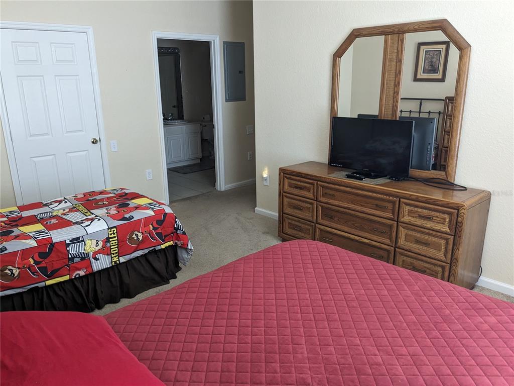 2817 Almaton Loop, Unit 304 Kissimmee, FL 34747 - Photo 13 of 26 a bedroom with a bed and a television