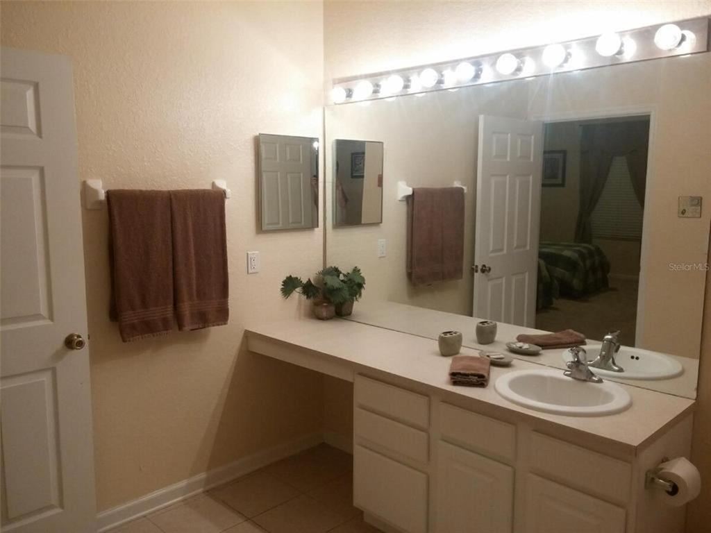 2817 Almaton Loop, Unit 304 Kissimmee, FL 34747 - Photo 15 of 26 a bathroom with a double vanity sink and mirror