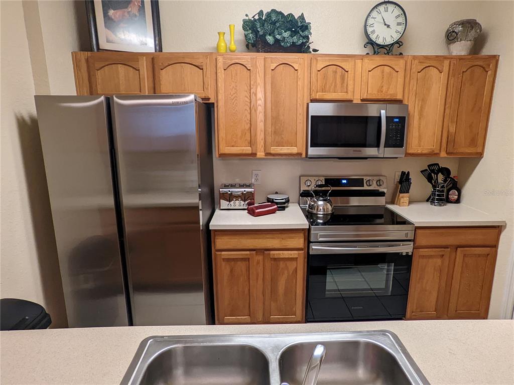 2817 Almaton Loop, Unit 304 Kissimmee, FL 34747 - Photo 5 of 26 a kitchen with stainless steel appliances granite countertop a refrigerator a stove a sink and dishwasher