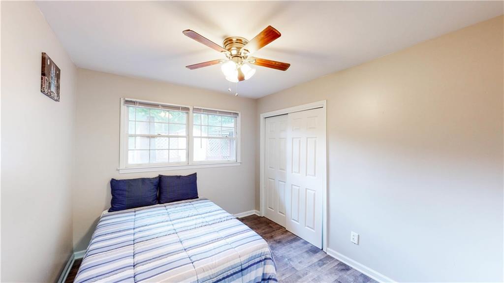 5960 Buffington Road Atlanta, GA 30349 - Photo 4 of 9 a bedroom with a large bed and a chandelier