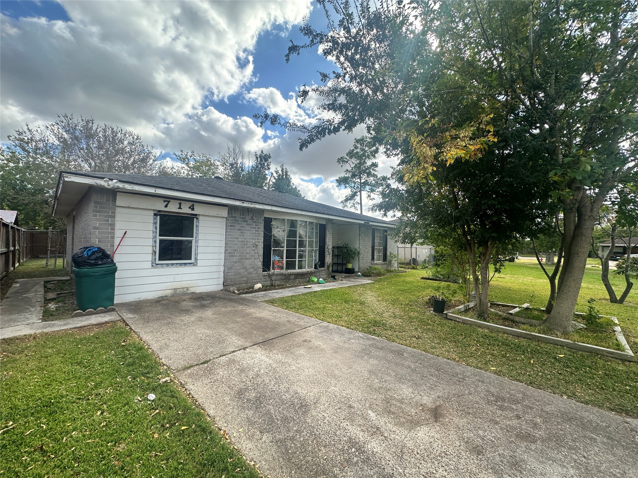 a view of a house with a yard and large tree