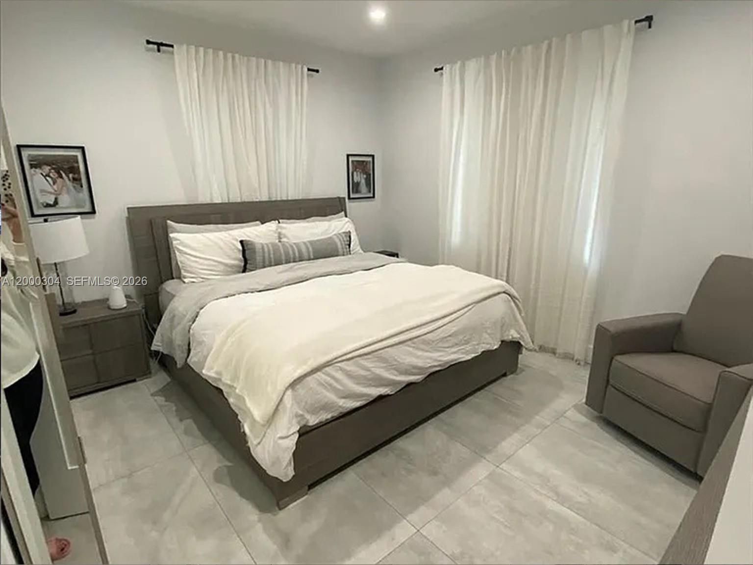 1935 Southwest 24th Terrace Miami, FL 33145 - Photo 4 of 7 a large bed sitting in a bedroom next to a window