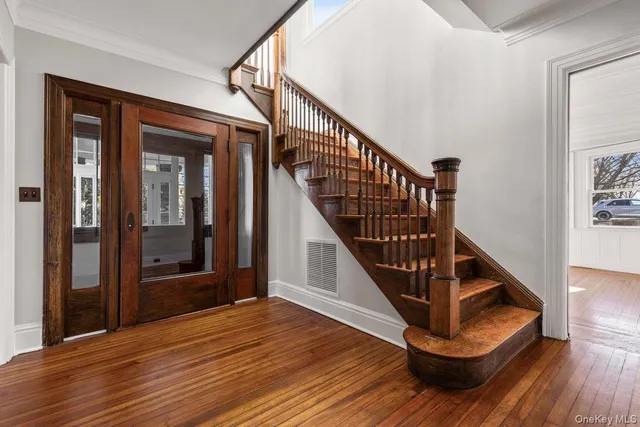a view of entryway with wooden floor and stairs