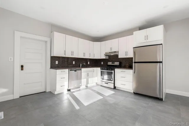 a kitchen with white cabinets and white appliances