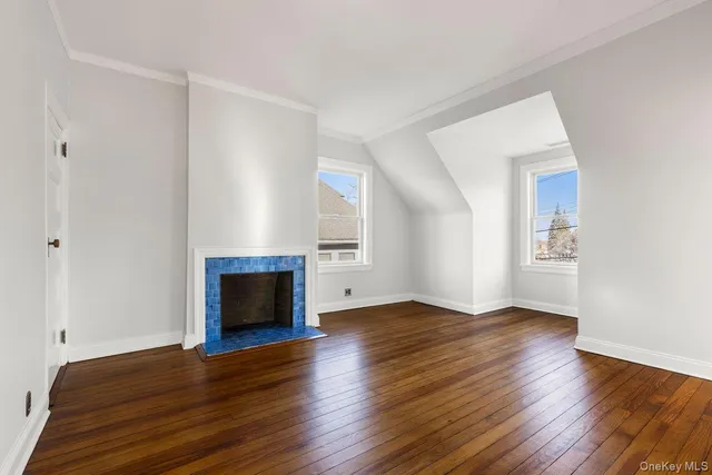 an empty room with wooden floor and fireplace