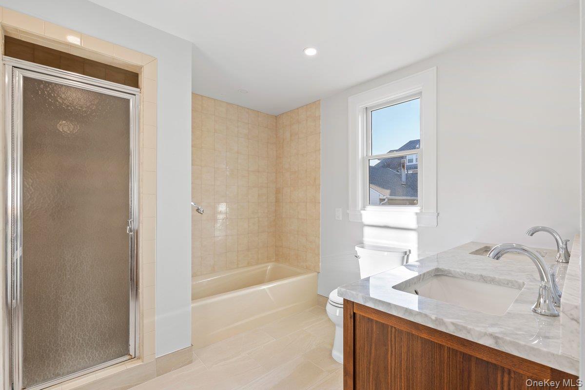 206 Fenimore Road Mamaroneck, NY 10543 - Photo 10 of 14 a bathroom with a granite countertop sink a mirror and a bathtub