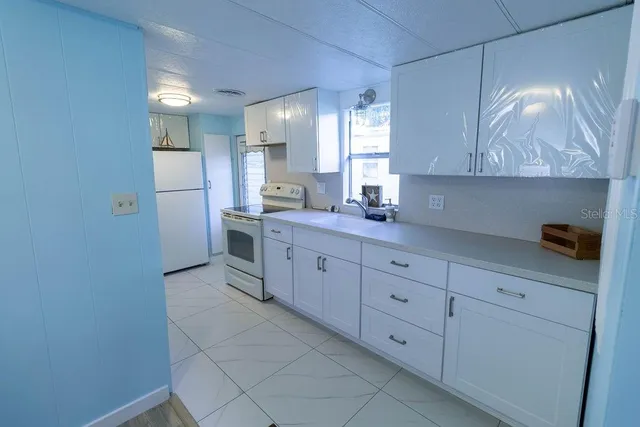 a kitchen with a sink dishwasher and a refrigerator