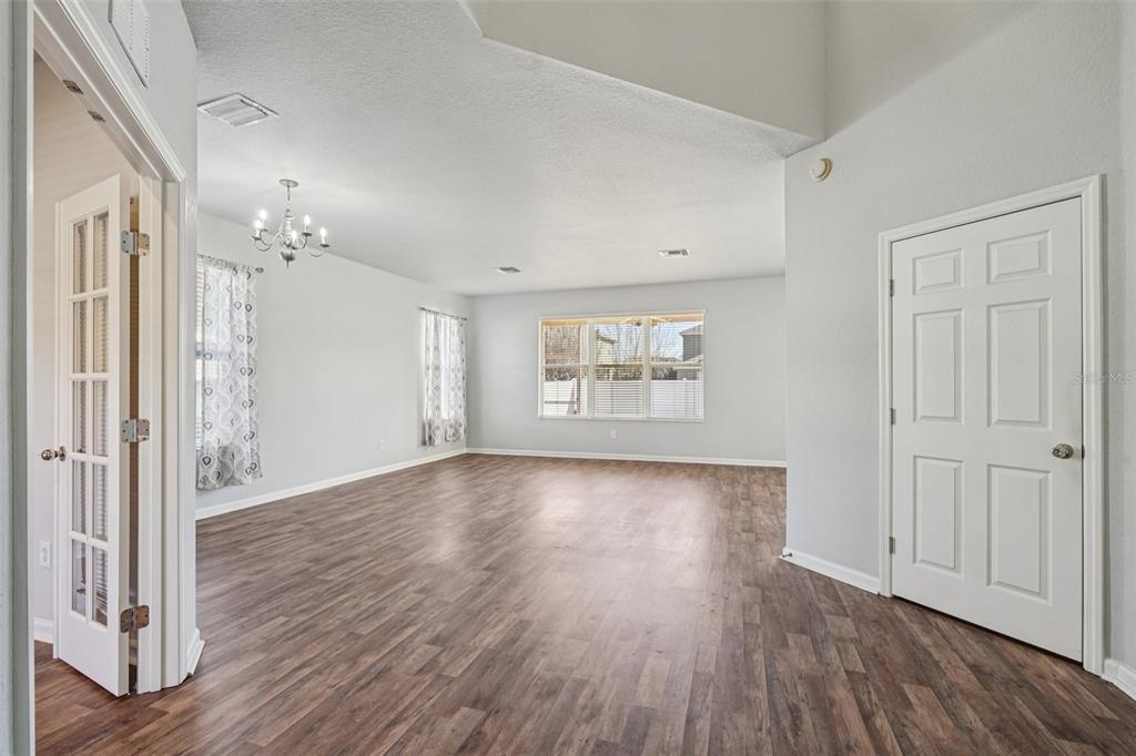 4127 Southwest 51st Court Ocala, FL 34474 - Photo 5 of 32 an empty room with wooden floor and windows