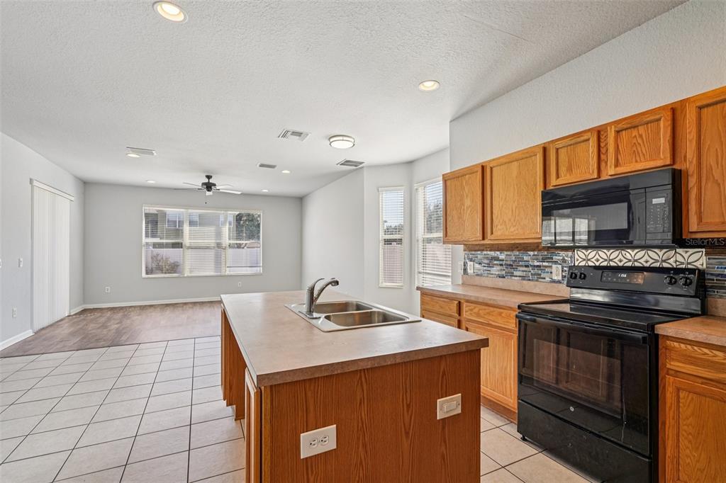 4127 Southwest 51st Court Ocala, FL 34474 - Photo 10 of 32 a kitchen that has a sink and a stove in it