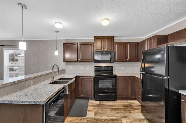 a kitchen with granite countertop a refrigerator stove top oven and sink