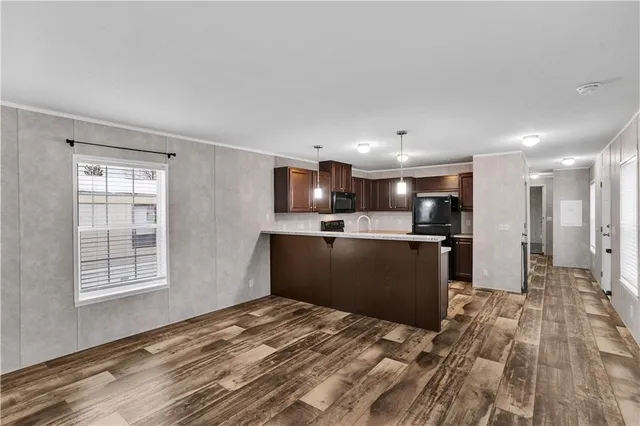 a kitchen with stainless steel appliances kitchen island granite countertop a refrigerator and a sink
