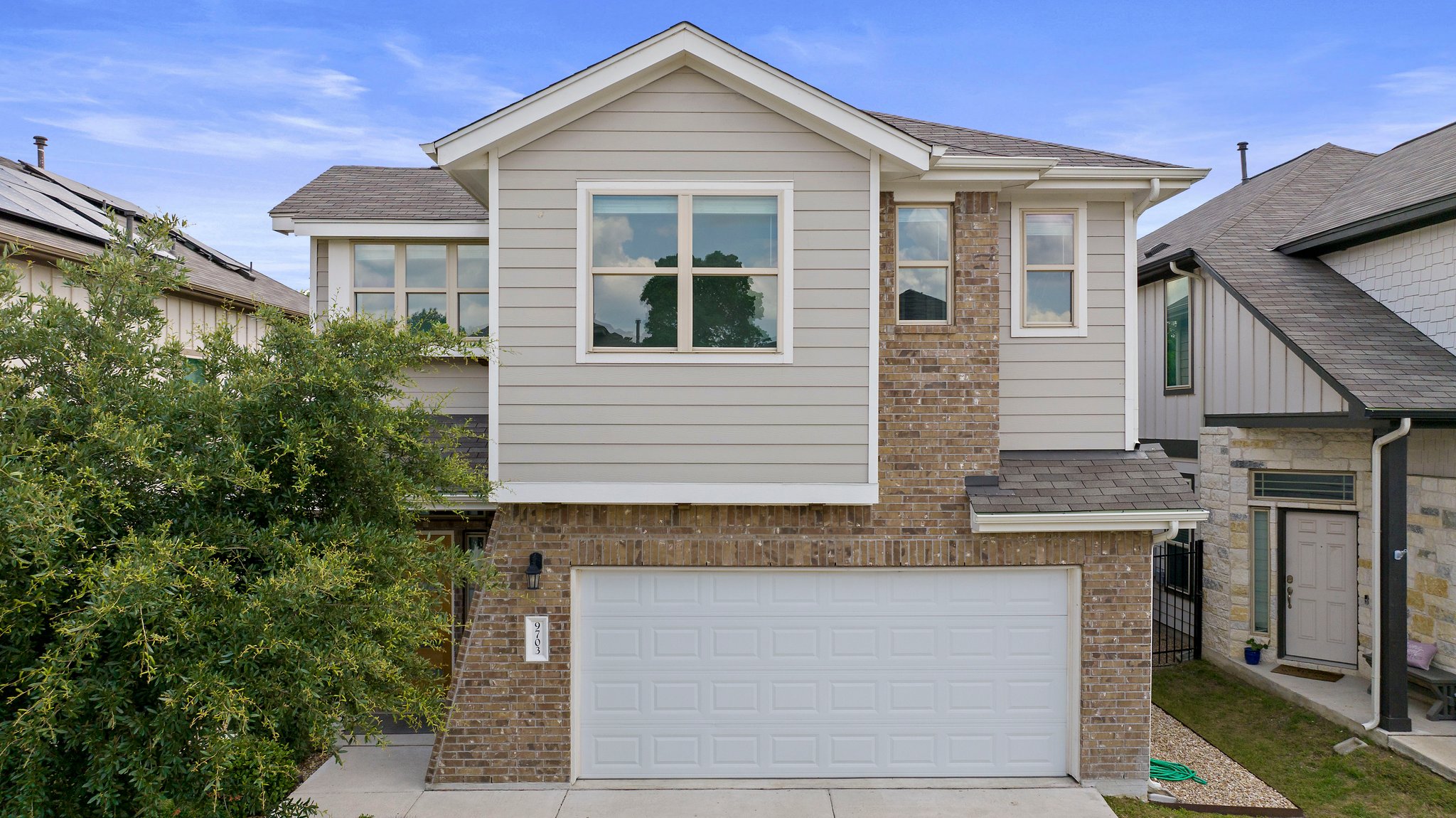 9703 Briny Shell Way Austin, TX 78748 - Photo 1 of 1 View of front of property with an attached garage, driveway, roof with shingles, and brick siding
