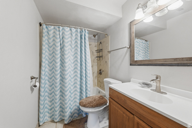 1700 Hickory Lane Provo, UT 84604 - Photo 17 of 20 Bathroom featuring a single vanity with wood-finish cabinetry, a white countertop, and brushed nickel fixtures