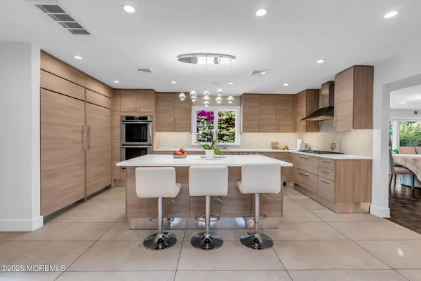 a large kitchen with stainless steel appliances kitchen island granite countertop a sink and cabinets