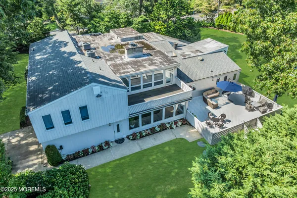 an aerial view of a house with a yard and trees all around