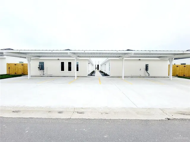 a view of a garden with a bench under an umbrella