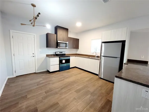 a kitchen with a refrigerator and a stove top oven