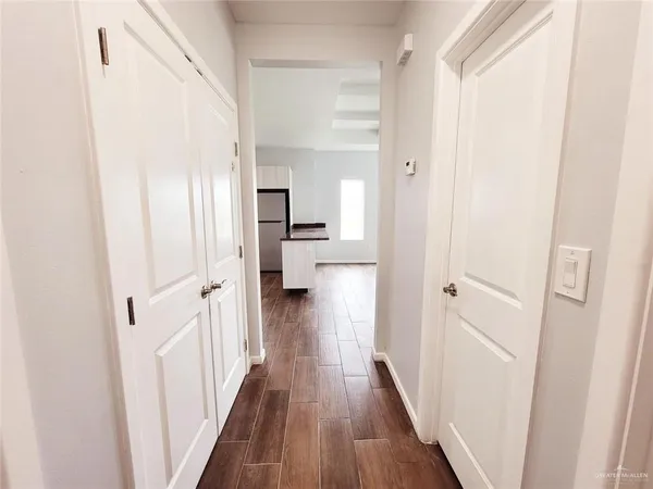 a view of a hallway with wooden floor