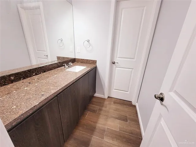 a bathroom with a granite countertop sink and a mirror