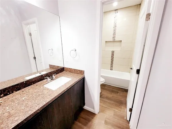 a bathroom with a granite countertop sink and a mirror